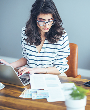 woman working at desk with glasses and laptop